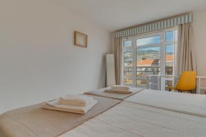 a bedroom with a bed with two towels on it at avenida arriaga 405 in Funchal
