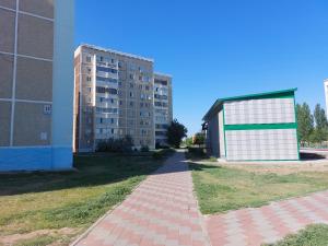 ein Gebäude neben einem Ziegelsteinweg neben einem Gebäude in der Unterkunft Уютная квартира с удобным расположением in Līsakovsk