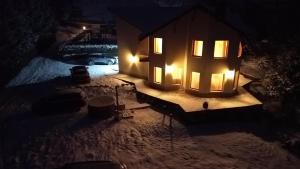 a house with lights on in the snow at night at TRYhaus 