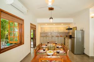 a kitchen with a table and a refrigerator at Aguada Anchorage - The Villa Resort, Candolim in Candolim