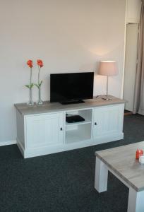 een wit entertainmentcentrum met een flatscreen-tv bij Apartments Bommels in Vierhouten