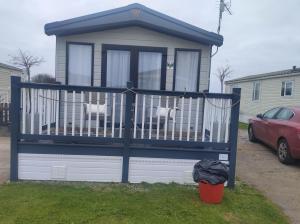 dois cães sentados num portão numa casa em 2021 2 bedroom static caravan in 5 stars Patrington haven holiday park em Patrington