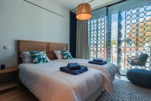 a bedroom with two beds and a large window at New Luxury Central Cascais in Cascais