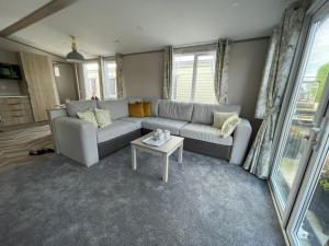 2021 2 bedroom static caravan in 5 stars Patrington haven holiday park في Patrington: غرفة معيشة مع أريكة وطاولة