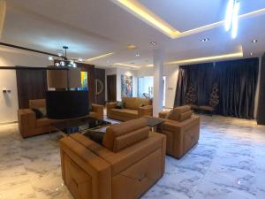 a living room with couches and a flat screen tv at Skyloft Suite in Lagos