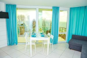 a dining room with blue curtains and a table and chairs at Апартаменти Дача in Varna City +50 photos