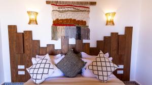 - une chambre avec un lit et une tête de lit en bois dans l'établissement Dakhla Attitude, à Dakhla