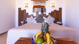um quarto com uma cama com uma tigela de fruta numa mesa em Dakhla Attitude em Dakhla