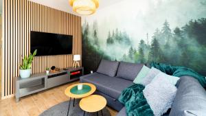 uma sala de estar com um sofá e uma televisão em Apartament Leśny Karpacz em Karpacz