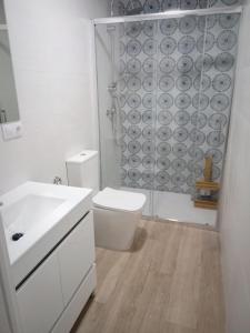 a white bathroom with a toilet and a shower at Apartamento Flor de Córdoba in Córdoba