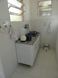 uma cozinha branca com um balcão e um lavatório em Hotel Coco Beach em Conde