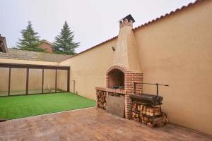 un patio trasero con barbacoa al aire libre y césped en Casa Rural Nueve Villas, en Amusco