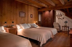 2 camas en una habitación con paredes de madera en Casa rural Casa Bernat, en Isil