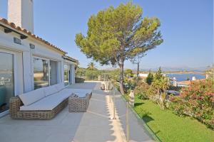 a patio with a couch and a tree on a house at Villa Odette in Alcudia