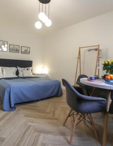 ein Schlafzimmer mit einem Bett, einem Tisch und einem Stuhl in der Unterkunft Apartament Żeromskiego 1 in Sandomierz