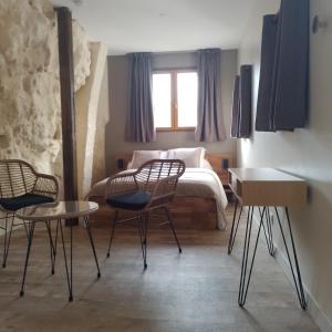 a bedroom with a bed and two chairs and a table at Ô 87 - chambres d'hôtes in Amboise