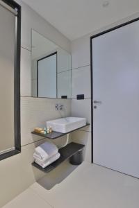 a bathroom with a sink and a mirror at Hotel Elements Surat in Surat +40 photos