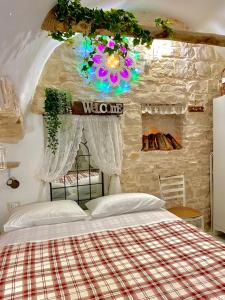 1 dormitorio con cama y pared de piedra en Domus Klara, en Turi