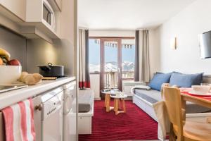 a kitchen and living room with a couch and a table at Résidence Antarès - Avoriaz in Avoriaz