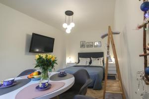 ein kleines Schlafzimmer mit einem Bett und einem Tisch mit Blumen in der Unterkunft Apartament Żeromskiego 1 in Sandomierz