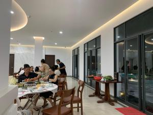 a group of people sitting at tables in a restaurant at Bờ Biển Vàng Resort in Ke Ga