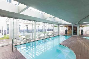 a swimming pool in a house with glass walls at BessaHotel Liberdade in Lisbon