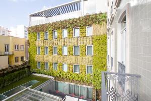 a building with ivy on the side of it at BessaHotel Liberdade in Lisbon