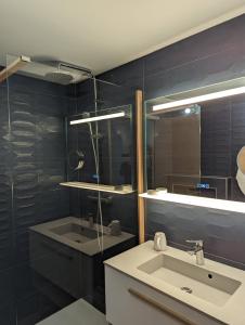 La salle de bains est pourvue d'un lavabo et d'un miroir. dans l'établissement Chalet Coste Belle, à La Fare-en-Champsaur