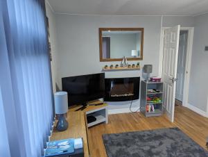 a living room with a television and a fireplace at 238b South shore in Bridlington