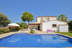 a villa with a swimming pool in front of a house at Villa Odette in Alcudia
