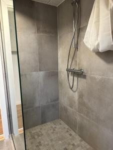 a shower with a glass door in a bathroom at Den gammel togstation in Give