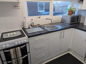 a small kitchen with a stove and a sink at 238b South shore in Bridlington