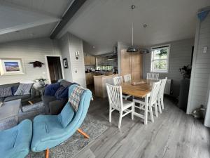 a kitchen and living room with a table and chairs at Holly Blue - Cosy wooden lodge Kippford in Dalbeattie