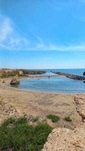 una spiaggia con persone che nuotano in acqua di Ciriga Sicily Glamping Resort a Santa Maria del Focallo