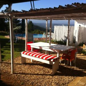 una mesa de picnic y un banco bajo una pérgola en Protea Wilds Retreat, en Harkerville