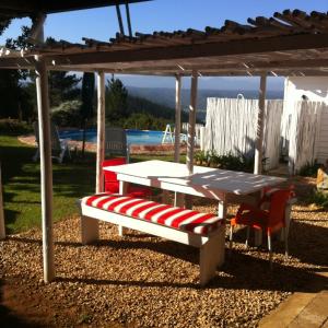 a picnic table and a bench under a pergola at Protea Wilds Retreat in Harkerville