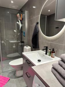 a bathroom with a sink and a toilet and a mirror at Hagastaden flat in Stockholm