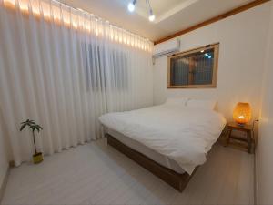 水原的住宿－Haenggung stay Dalno - Suwon private house hanok，卧室配有白色的床和窗户。