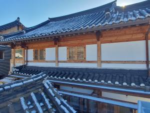 Azjatycki budynek ze śniegiem na dachu w obiekcie Haenggung stay Dalno - Suwon private house hanok w mieście Suwon