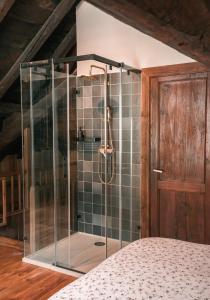 una ducha con un recinto de cristal en un dormitorio en Casa rural Casa Bernat en Isil