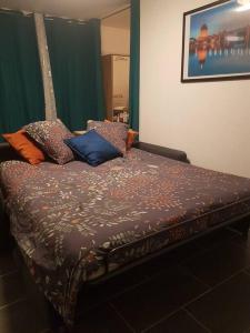 uma cama com almofadas num quarto em APPT Cosy entier avec piscine em Toulouse
