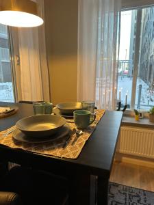 a table with plates and bowls on top of it at Hagastaden flat in Stockholm