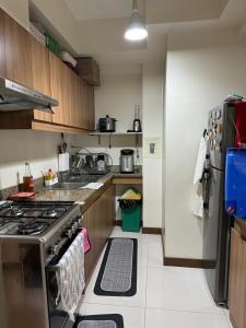 a kitchen with a stove and a refrigerator at 2BR Condo Unit at Prisma Residences in Manila