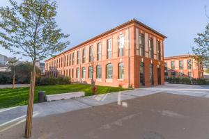图卢兹Montempô + Apparthôtel Toulouse Cité Internationale的一座砖砌的大建筑，前面有一棵树