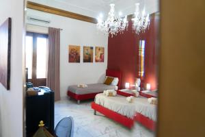 a living room with two beds and a chandelier at B&B Opera in Catania