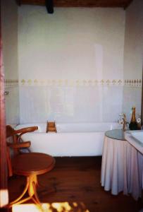 baño con bañera, mesa y taburete en Protea Wilds Retreat, en Harkerville