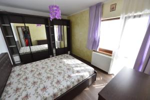 Schlafzimmer mit einem Bett, einem Tisch und einem Spiegel in der Unterkunft Apartament Astra BN70 in Braşov