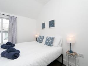 a bedroom with a white bed with blue towels on it at Pass the Keys Breeze Cottage 2 bed Beach property in Rhosneigr