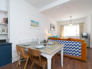 a dining room with a table and a couch at Pass the Keys Breeze Cottage 2 bed Beach property in Rhosneigr