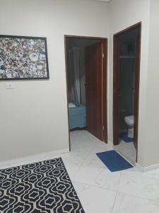 a room with a bathroom with a toilet and a rug at POUSADA FLAT MÃE RAINHA in Maceió